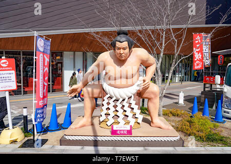 Osaka, Giappone - 4 Mar 2018 - Statua di Sumo accanto ai tradizionali Japan food carrello. il tavolo e sedia sono intorno alla zona e a stabilirsi sul footpart in Foto Stock