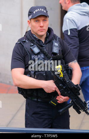 Un agente di polizia armato di turno durante il Tour de Yorkshire in Leeds City Centre Foto Stock