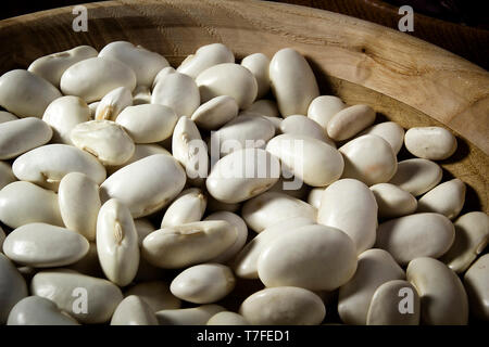 I fagioli in un piatto di legno sul tavolo Foto Stock