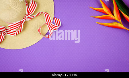 La vacanza estiva tema flatlay sovraccarico con cappello su sfondo viola. Foto Stock