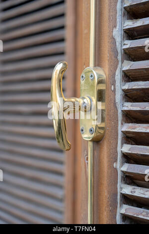 Chiuso persiane in legno persiane e metallo handle della finestra, chiudere fino Foto Stock