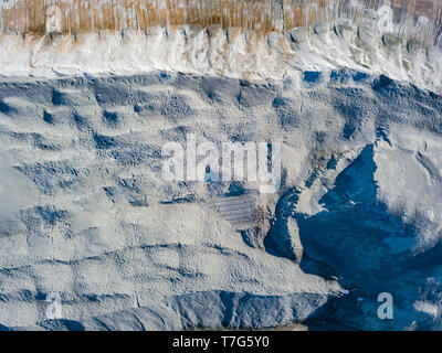 Vista aerea di un mucchio di pietrisco e cemento grigio nei pressi di un impianto per la produzione di materiali da costruzione per edilizia e industria. Extracti Foto Stock