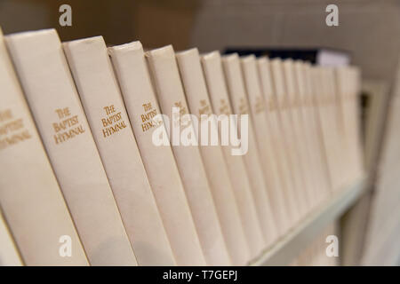 Hymnals bianco su un ripiano, contenenti musica e canzoni utilizzato per il culto in una chiesa cristiana Foto Stock