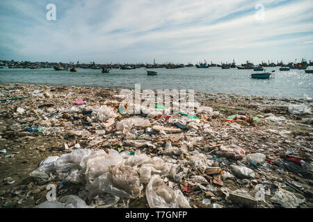 Garbage e cesto barche sulla spiaggia. Cattiva situazione ambientale vicino al mare in Vietnam. MUI ne. Villaggio di Pescatori. Foto Stock