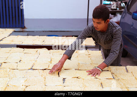 Lavoratore tendendo il vento essiccato yuba, un tipo di Yong Tau Foo cibo in Malesia. Foto Stock