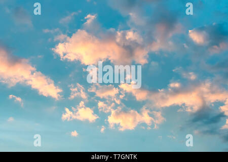 Sfondo nuvola con un colore pastello. Nuvole rosa contro un cielo blu al tramonto. Foto Stock