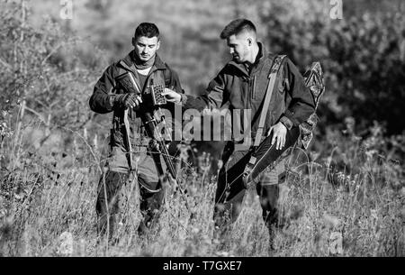 Amicizia di uomini cacciatori. Uniforme militare di moda. Forze armate. Il camuffamento. Abilità di caccia e di apparecchiature di arma. Come ruotare la caccia in hobby. I cacciatori di uomo con un fucile pistola. Boot camp. per il successo. Foto Stock