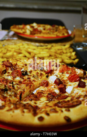 Pizze e patatine fritte sul tavolo di legno Foto Stock