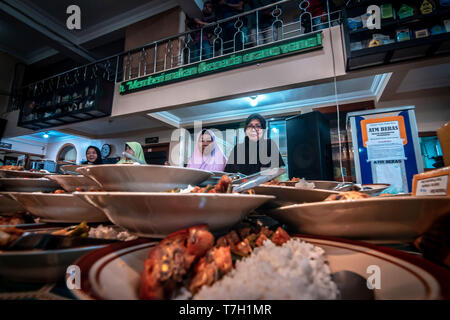 Piastre di cibo di musulmani indonesiani si sono riuniti per iftar (fast-breaking) Cena visto durante il mese sacro del Ramadan alla Moschea Jogokariyan in Yogyakarta, Indonesia. I musulmani di tutto il mondo celebrano il mese sacro del Ramadan pregando durante la notte e di astenersi dal mangiare e dal bere durante il periodo compreso tra gli orari di alba e tramonto. Foto Stock