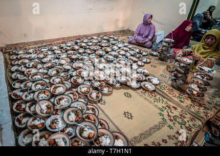 Piastre di cibo di musulmani indonesiani si sono riuniti per iftar (fast-breaking) Cena visto durante il mese sacro del Ramadan alla Moschea Jogokariyan in Yogyakarta, Indonesia. I musulmani di tutto il mondo celebrano il mese sacro del Ramadan pregando durante la notte e di astenersi dal mangiare e dal bere durante il periodo compreso tra gli orari di alba e tramonto. Foto Stock