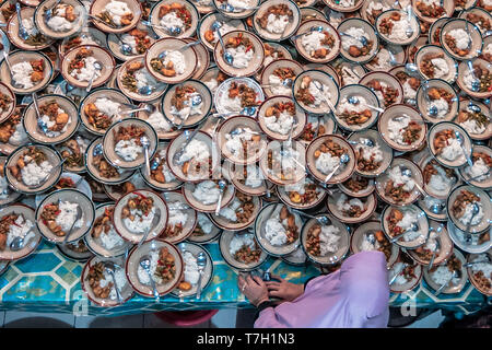 Piastre di cibo di musulmani indonesiani si sono riuniti per iftar (fast-breaking) Cena visto durante il mese sacro del Ramadan alla Moschea Jogokariyan in Yogyakarta, Indonesia. I musulmani di tutto il mondo celebrano il mese sacro del Ramadan pregando durante la notte e di astenersi dal mangiare e dal bere durante il periodo compreso tra gli orari di alba e tramonto. Foto Stock