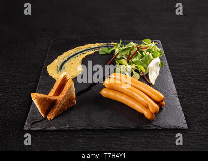 Frankfurters servita su nero ardesia Foto Stock