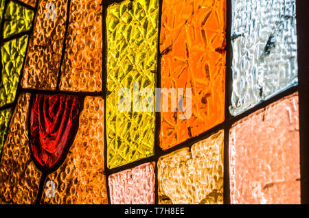 Di sezione rettangolare e circolare vetrata con rosa rossa. Geometrica astratta sfondo colorato. Multicolore di vetro macchiato la finestra della chiesa con irregu Foto Stock