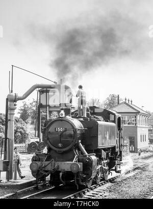 Locomotiva a vapore inglese monocolore in sidings alla stazione ferroviaria di Severn Valley Kidderminster che porta in acqua, equipaggio di treno a vapore con gru di arresto dell'acqua. Foto Stock