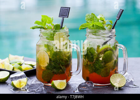 Cocktail Mojito in vasetti di vetro blu su sfondo d'acqua. Copia dello spazio. Foto Stock