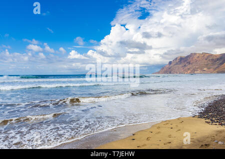 Spiaggia di Famara a bassa marea con le isole dell Arcipelago Chinijo in background con cielo molto nuvoloso Foto Stock