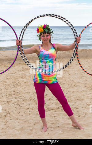 Lottie lucido con la sua hula hoops su Boscombe Beach, Bournemouth Dorset Regno Unito nel mese di maggio Foto Stock