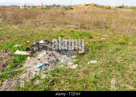 Rifiuti bruciati in un campo Foto Stock