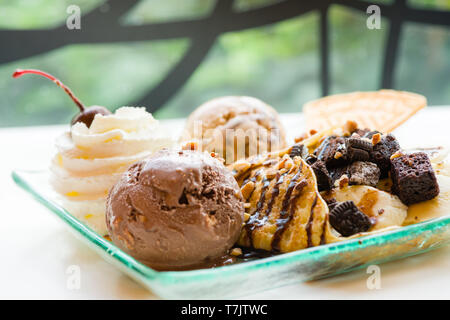 Gustosi pancake con gelato al cioccolato cialda croccante di panna montata con brownies ciliegia e mandorla sciroppo di cioccolato sulla parte superiore.servite frittelle crepes sul pl Foto Stock