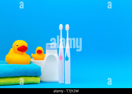 Due gli spazzolini da denti elettrici e accessori per il bagno su sfondo blu Foto Stock