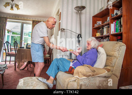 93 anno vecchio con condizione di cuore si prende cura della sua ipovedenti di 90 anni moglie e cuochi,prepaeres pasti e fa i lavori di casa per lei. Foto Stock