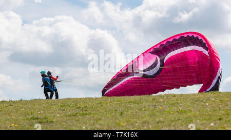 Devils Dyke, Sussex, Regno Unito; 6 maggio 2019; maschio e femmina parapendii tenta di decollare da un pendio Foto Stock