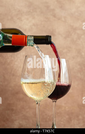 Vino bianco e rosso versando in bicchieri di close-up Foto Stock