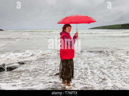 Fountainstown, Cork, Irlanda. 08 Maggio, 2019. Brigita De Coppet dalla Lettonia chi è in visita a suo figlio , viene preso dalla marea in un giorno di pioggia in Fountainstown, Co. Cork, Irlanda. Credito: David Creedon/Alamy Live News Foto Stock