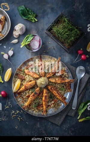 Sabzi Polo va Mahi - erborinati persiano di riso e il pesce fritto in padella Foto Stock