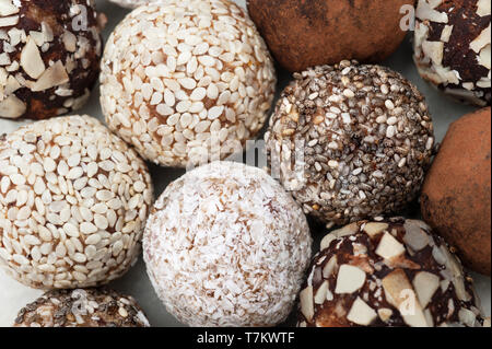 Sfera di energia con frutta secca, sesamo, biancheria, noci ,scaglie di cocco. Close up, macro,vegane in casa candy.Background texture macro.messa a fuoco selettiva. Foto Stock