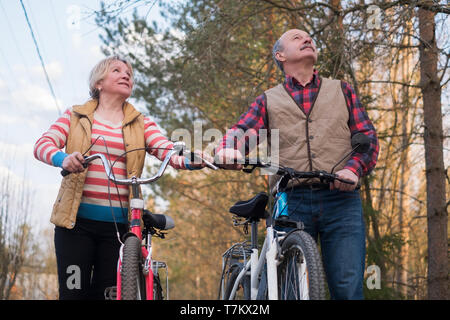 Felice anziani coppia senior in bicicletta nel parco Foto Stock