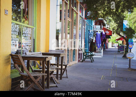 Una vista verso il basso il marciapiede ombreggiato storico di 4° Avenue, rivelando una casual, cool mix di pub , boutique e ristoranti nel centro cittadino di Tucson, AZ Foto Stock