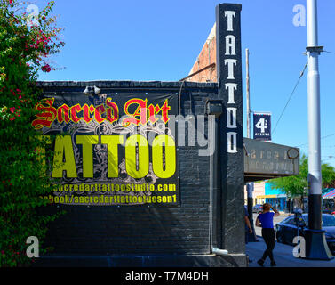 Arte sacra tattoo studio ha un caratteristico edificio di colore nero con il giallo e il rosso logo dipinta sulla parete esterna nella storica quarta Avenue a Tucson, AZ Foto Stock