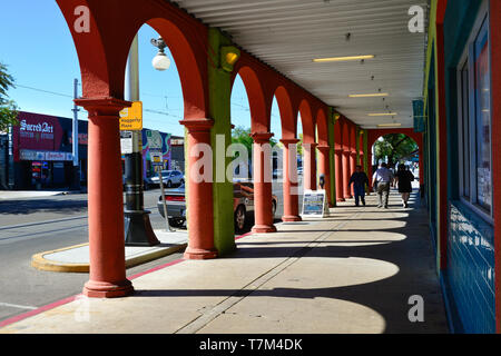 La gente di passeggiare lungo la colorata in stile spagnolo passerella portale nella parte anteriore del negozio di buona volontà sulla storica 4a Avenue, nel centro cittadino di Tucson, AZ Foto Stock