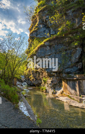 Splendida vista del Torrente Vertova al tramonto, nel mezzo delle montagne Orobiche con la sua bella piccola cascate. Foto Stock