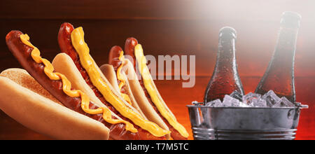 Quattro grandi American hotdog e due bottiglie di birra fredda Foto Stock