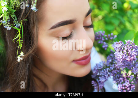 Bella giovane donna con fiori di fioritura in primavera Foto Stock