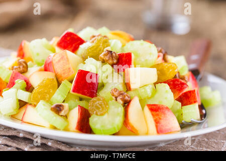 Fresca Insalata Waldorf fatta di sedano, mele, noci, uva sultanina e uva passa sulla piastra (fuoco selettivo, la messa a fuoco di un terzo nell'insalata) Foto Stock