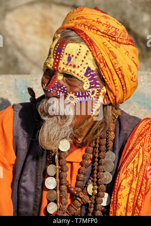 Ritratto di un sadhu (uomo santo) con faccia dipinta, rivestiti in arancione vesti, Pashupatinath tempio indù, Valle di Kathmandu, Nepal Foto Stock