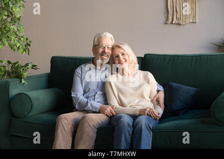 Ritratto di avvolgente di età compresa tra un uomo e una donna, la famiglia seduta sul lettino Foto Stock