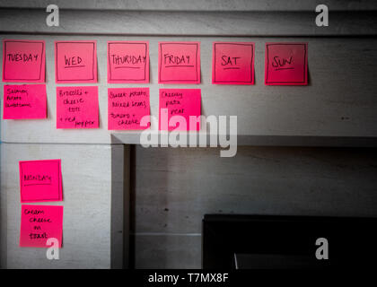 Una luminosa immagine astratta di un pasto elenco e i giorni della settimana in rosa sticky notes Foto Stock