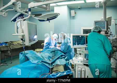 Sala operatoria, chirurghi eseguono un'operazione, un team professionale di chirurghi che lavorano in sala operatoria con attrezzature moderne. Foto Stock