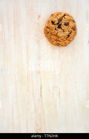 Home freschi cotti di noce macadamia e cioccolato chunk cookie nella piana composizione laici sul legno rustico sfondo. Mangiare sano concetto. Foto Stock