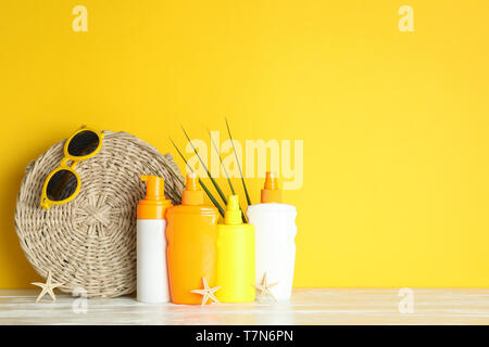 La vacanza estiva accessori sul tavolo bianco contro il colore di sfondo, spazio per il testo. Abbronzatura sicura Foto Stock