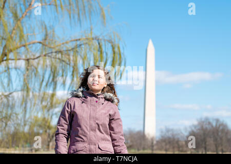 Primo piano della giovane donna femmina cercando fino a visualizzare sul Monumento di Washington con willow tree rami foglie verdi in DC in primavera Foto Stock