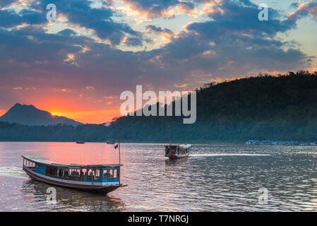 Barche sul fiume Mekong a Luang Prabang, Laos, tramonto Cielo drammatico, famosa destinazione di viaggio backpacker nel Sud Est asiatico Foto Stock