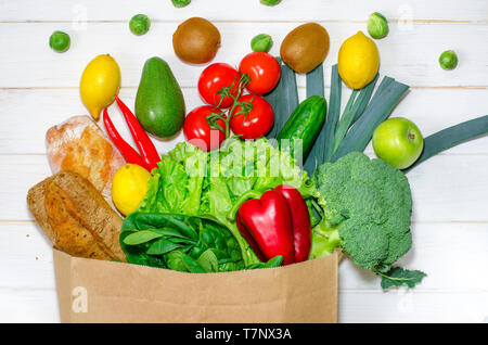 Sacchetto di carta di diversa della salute alimentare su bianco sullo sfondo di legno. Vista superiore Foto Stock