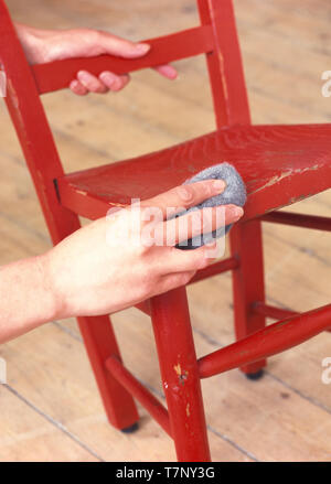 Close-up di mani giù di sfregamento del bambino sedia in legno Foto Stock