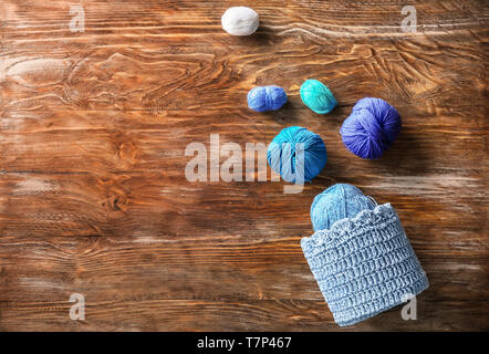 Cestello con sfere di filato per maglieria sul tavolo di legno Foto Stock