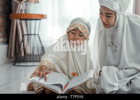 Musulmani e madre figlia leggere il Corano Foto Stock